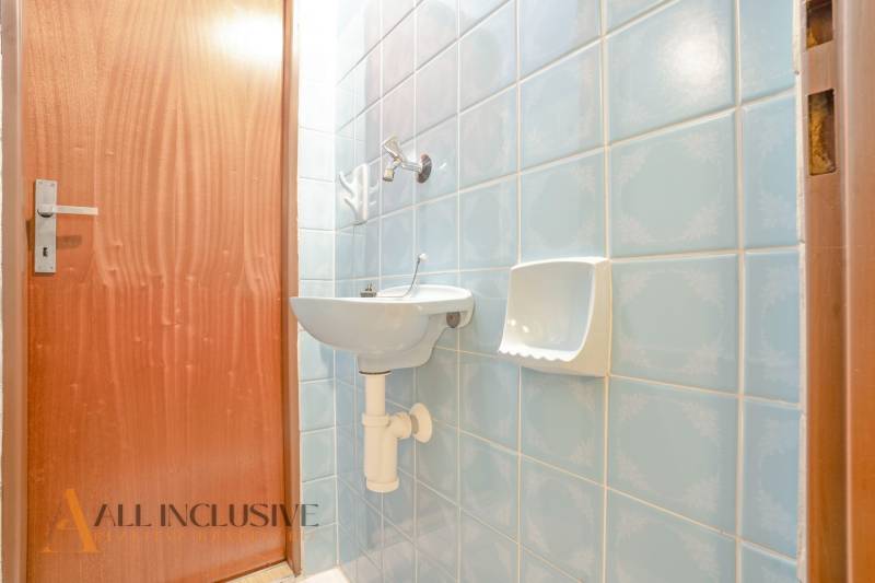 Blue bathroom in a family house with a sink and wooden door.