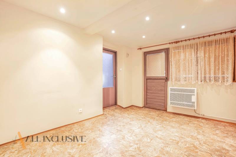 Interior of a room in a family house with doors, laminate flooring, and curtains.