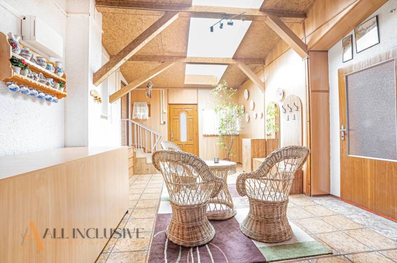 Rustic interior of a family house with wicker furniture and wooden elements.