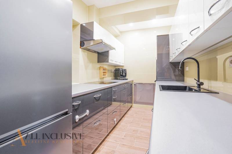 Spacious kitchen in a family house with glossy cabinets and modern appliances.