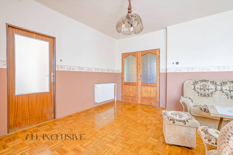 Wooden doors, wall-mounted radiators, and a patterned sofa in a family house.