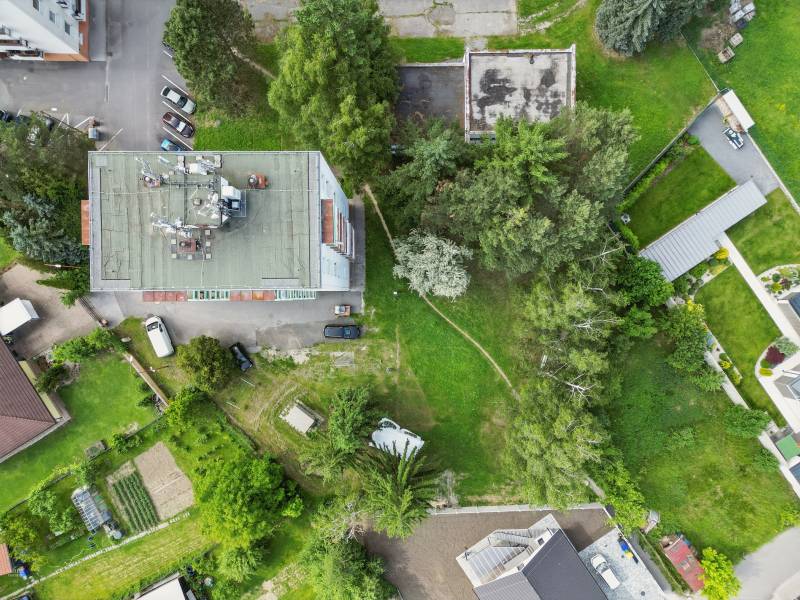 Aerial view of plots - housing on Slnečná Street in Kováčová, surrounded by greenery and cars.