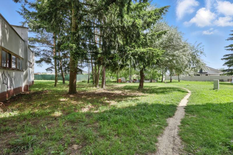 Grassy area with a path and trees on Slnečná Street in Kováčová, plots - housing.