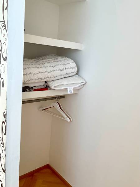 Storage space with folded clothes and hangers in a 2-room apartment.