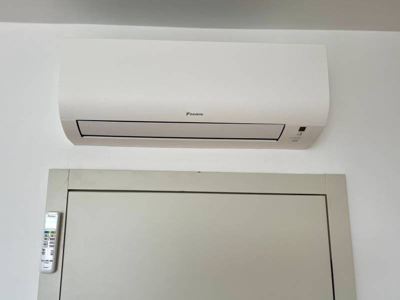 Air conditioning with a remote control on the wall of a 2-room apartment.