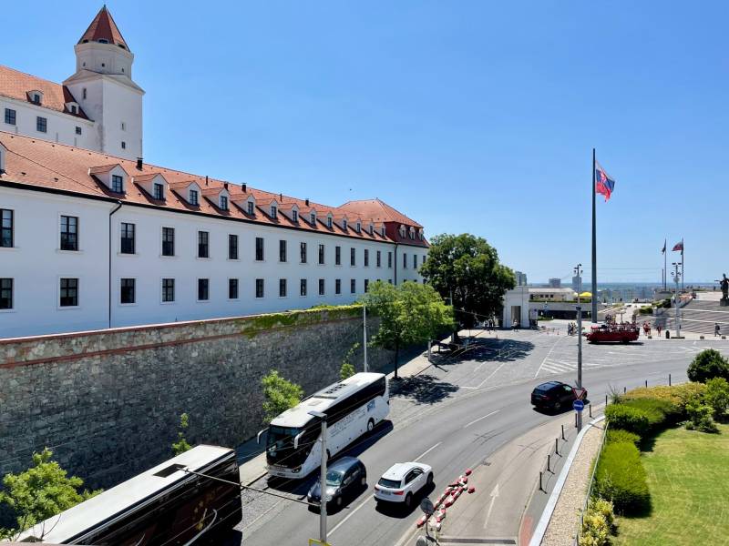 Bratislava Castle with buses and cars on the road in Bratislava - Old Town.