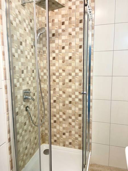 Shower corner with ceramic tiles in a 2-room apartment.