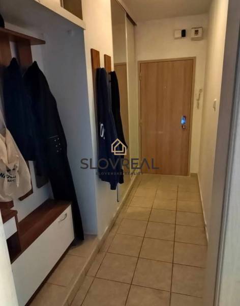Entrance hallway in a 3-room apartment with a coat rack and tiles.