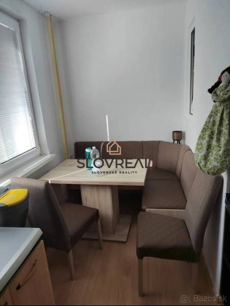 Dining area with a sofa and table in a 3-room apartment, minimalist furnishings.
