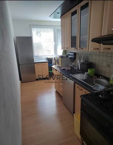 A kitchen in a 3-room apartment with a bright interior and wooden cabinets.