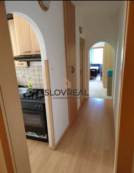 A hallway with entrances to the kitchen and a room in a 3-room apartment.