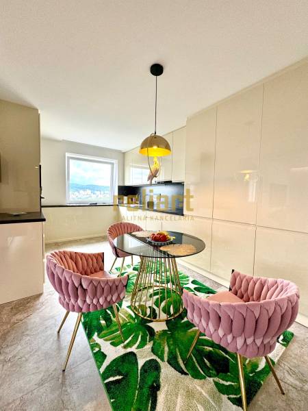 Dining area with a glass table and pink chairs in a 3-room apartment.