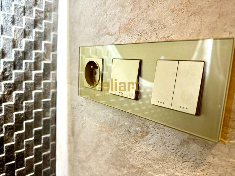 Sockets and switches on a stone wall in a 3-room apartment.