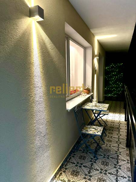 Balcony of a 3-room apartment with decorative tiles and wall lighting.