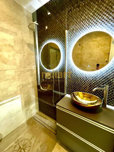 Luxury bathroom with LED mirror and gold washbasin in a 3-room apartment.