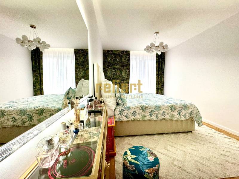 A bedroom in a three-room apartment with an elegant mirror and floral pattern.