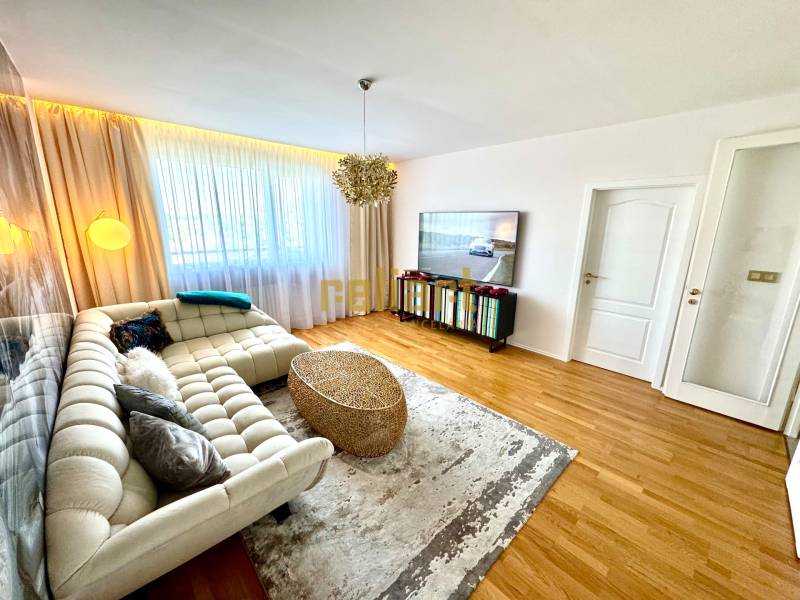 Living room in a 3-room apartment with a sofa, television, and curtains on the window.