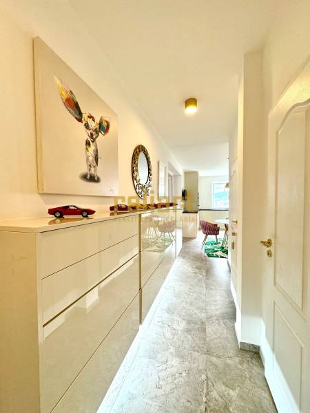 Interior of a 3-room apartment with a bright corridor, art, and furniture.