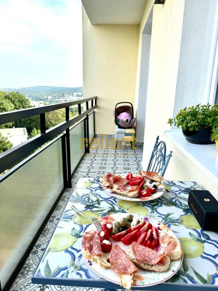 Balcony of a 3-room apartment with a view, food, and a baby stroller.