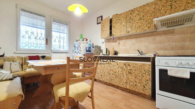 A kitchen in a 3-room apartment with wooden furniture and patterned cabinets.