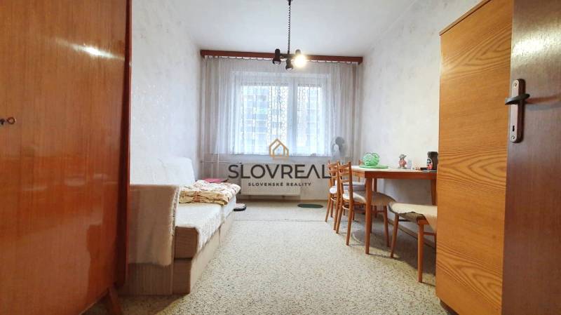 Living room in a 3-room apartment, with retro furniture and a window that lets in light.