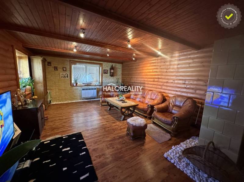 A kitchen with a wooden ceiling and floor in a family house, with dining and equipment.