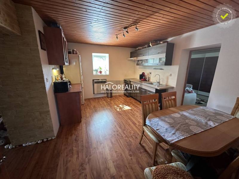 Wooden interior of the kitchen with a dining table and kitchen unit in a family house.