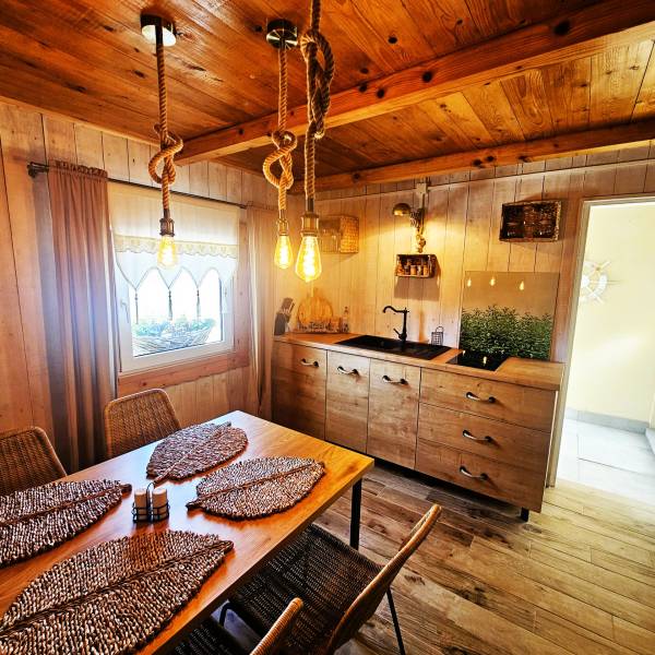 Interior of a cottage with wooden furniture, kitchen unit, and decorative elements.