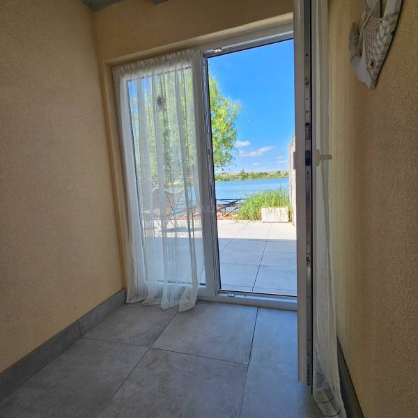 Through the open doors of the cabin, you can see the terrace with a view of the lake.