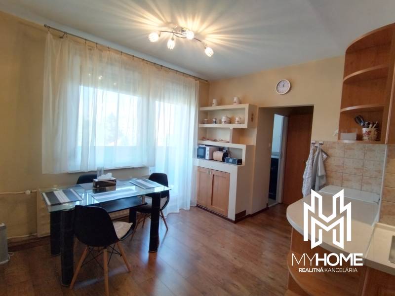 Dining table with chairs in the kitchen of a 3-room apartment, wooden floor.
