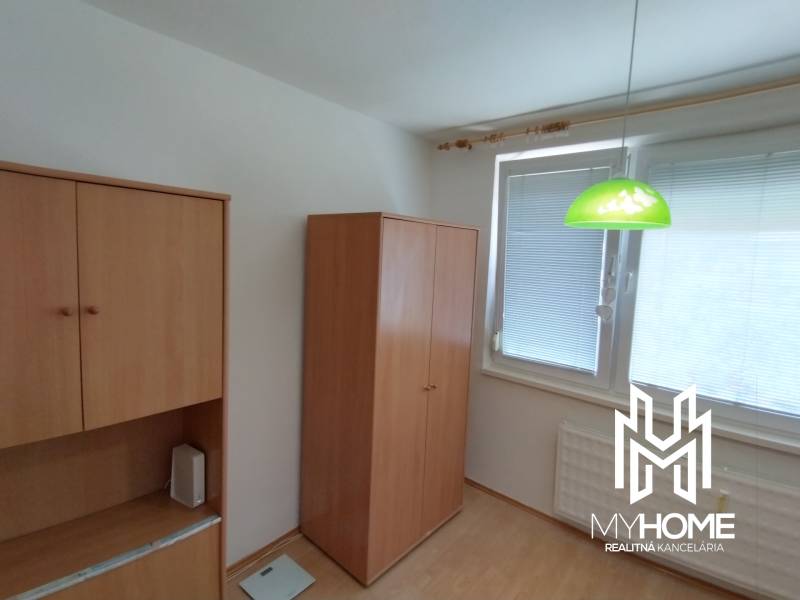 Interior of a 3-room apartment with a wooden wardrobe and a green hanging lamp.