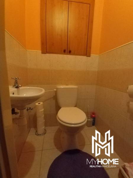 A toilet with a cabinet in a 3-room apartment, light tiles, yellow walls.