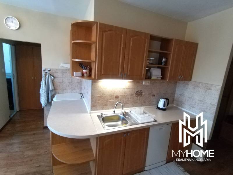 A kitchen in a 3-room apartment with a wooden cabinet, a sink, and a coffee maker.