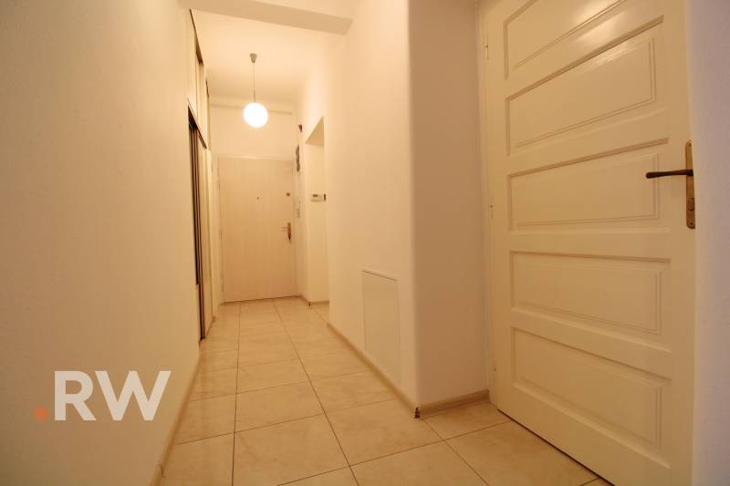 A narrow hallway with ceramic tiles and white doors in a 3-room apartment.
