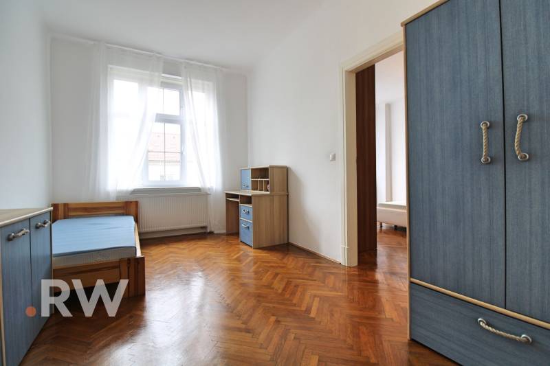 A bright room in a 3-room apartment with a stylish blue wardrobe and a desk.