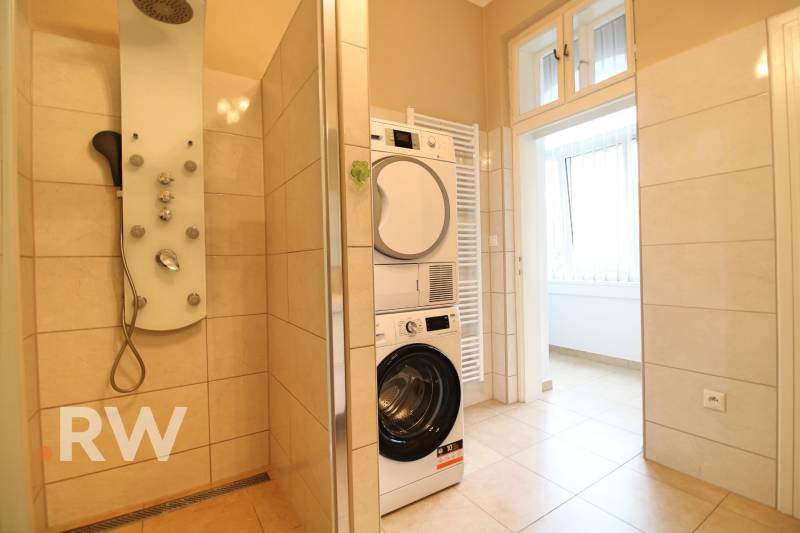 Bathroom with a washing machine, shower corner, and radiator in a 3-room apartment.