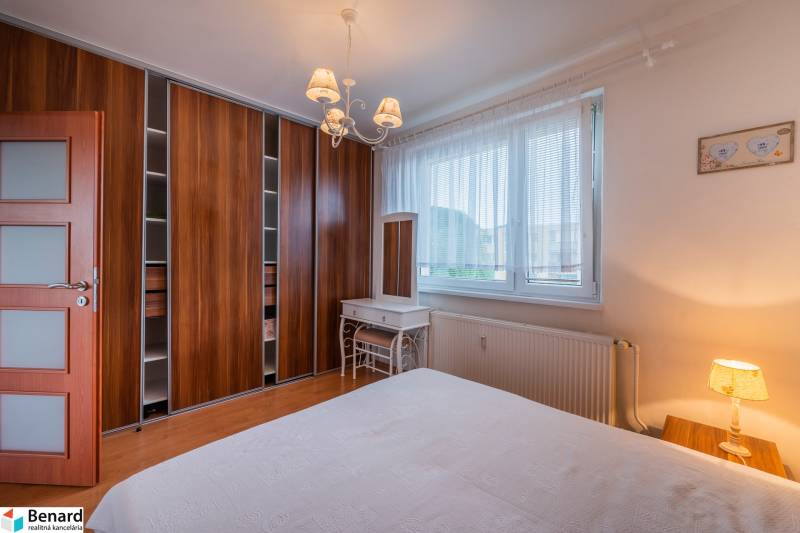 Bedroom in a 3-room apartment with a built-in wardrobe, window, and table.