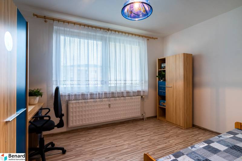 A bright room with a desk, chair, wardrobe, and bed in a 3-room apartment.