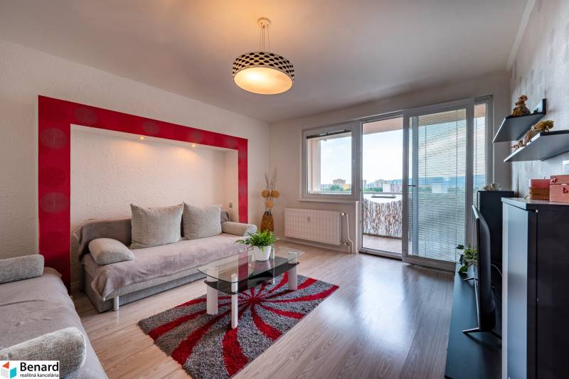 Living room in a 3-room apartment with a sofa, balcony, and television.