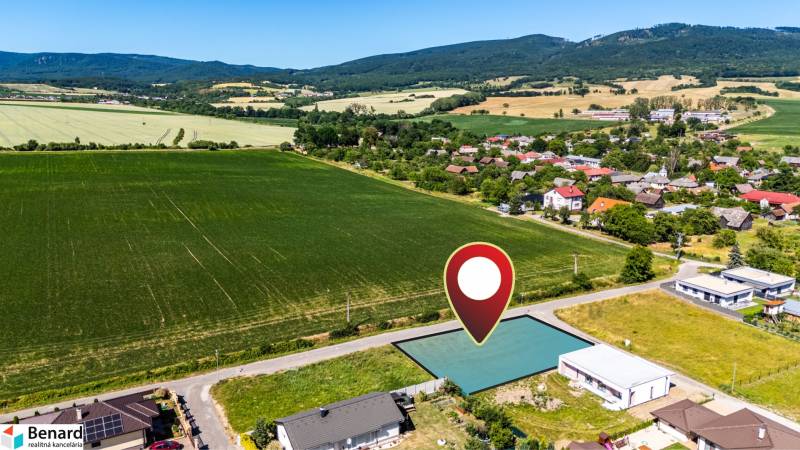 Aerial view of residential plots in Nižná Kamenica, surrounded by greenery and the village.