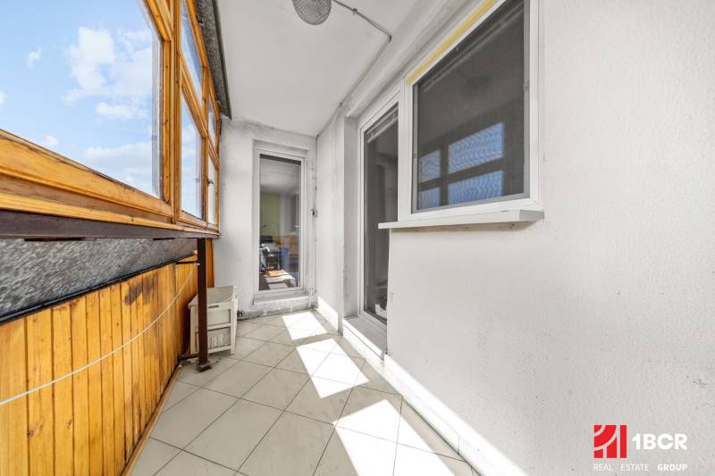 Glazed balcony with white walls and wooden paneling, 3-room apartment.