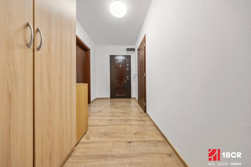 A hallway inside a 3-room apartment with an entrance door and a built-in wardrobe.