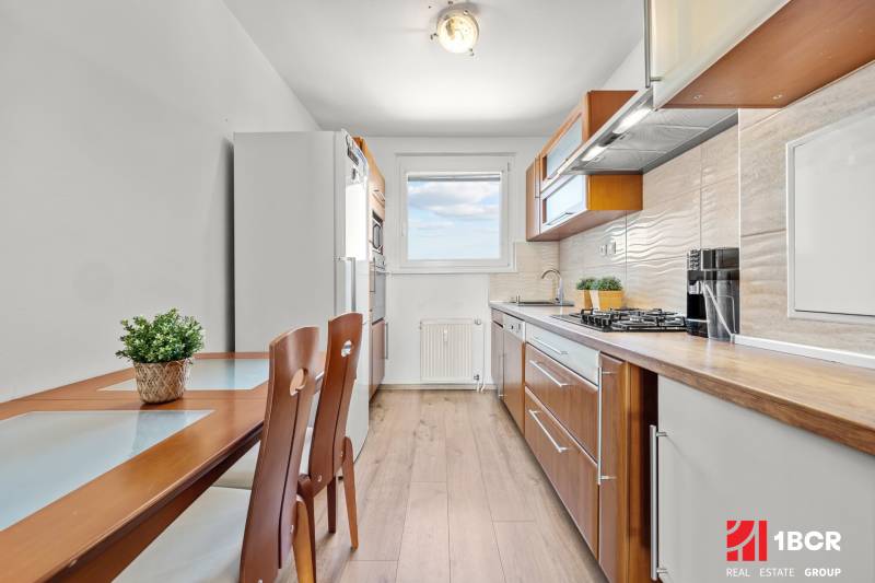 A kitchen in a 3-room apartment with a dining table and wooden accessories.