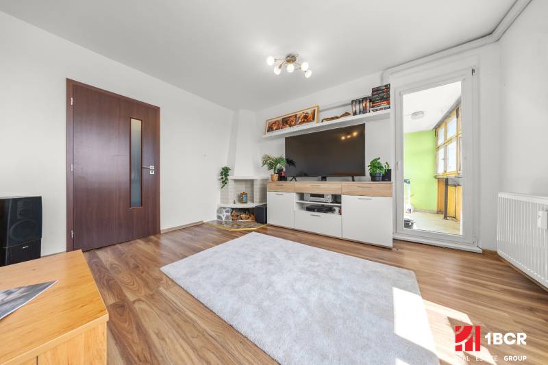 Living room in a 3-room apartment with a sofa, television, and access to the balcony.