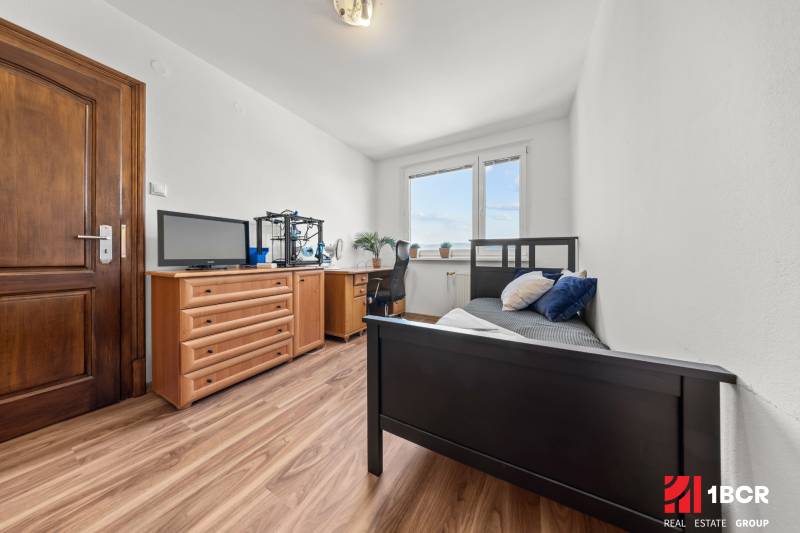 A room in a 3-room apartment with a bed, a dresser, and a desk, interior.