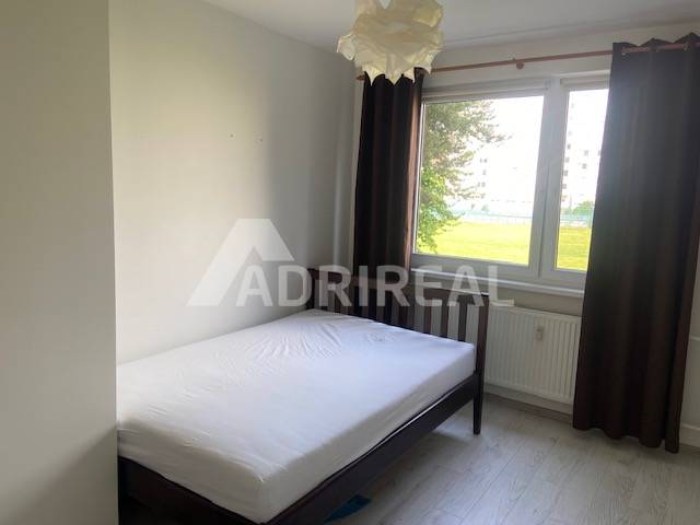 Bright bedroom with a bed and a large window in a 3-room apartment.