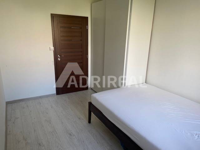 A room in a 3-room apartment with a built-in wardrobe and a bed, light floors.