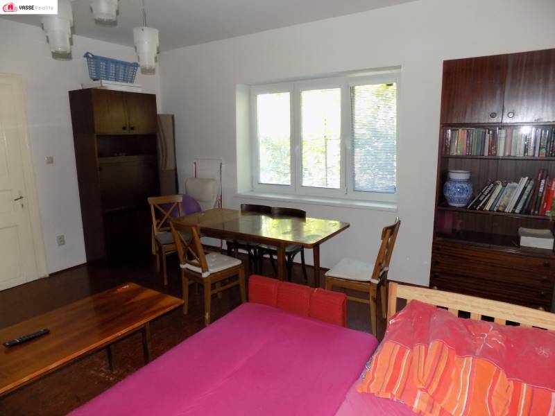 Living room in a family house with a library, sofa, and dining table.