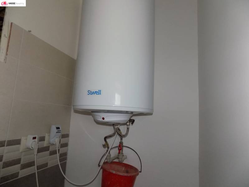 Hot water tank with installation and tiles in a family house.