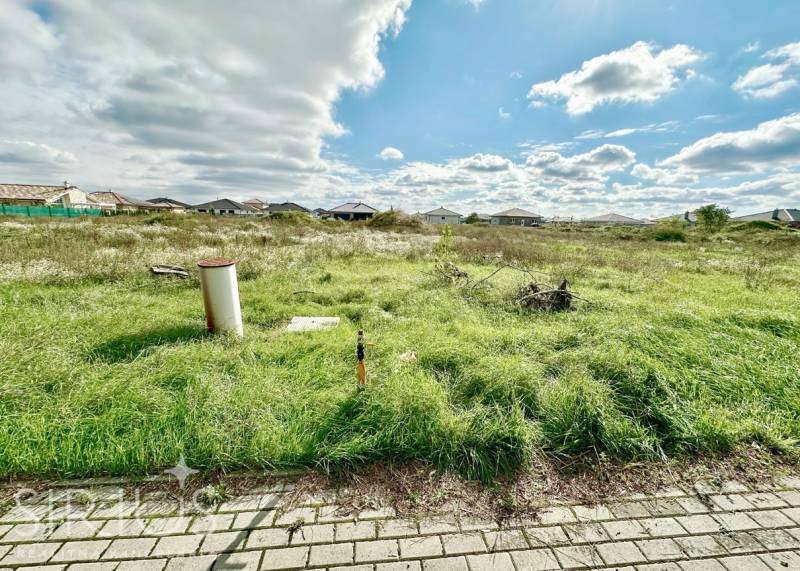 A grassy plot at Južná Brána, Senec, suitable for living, with a view of the houses.